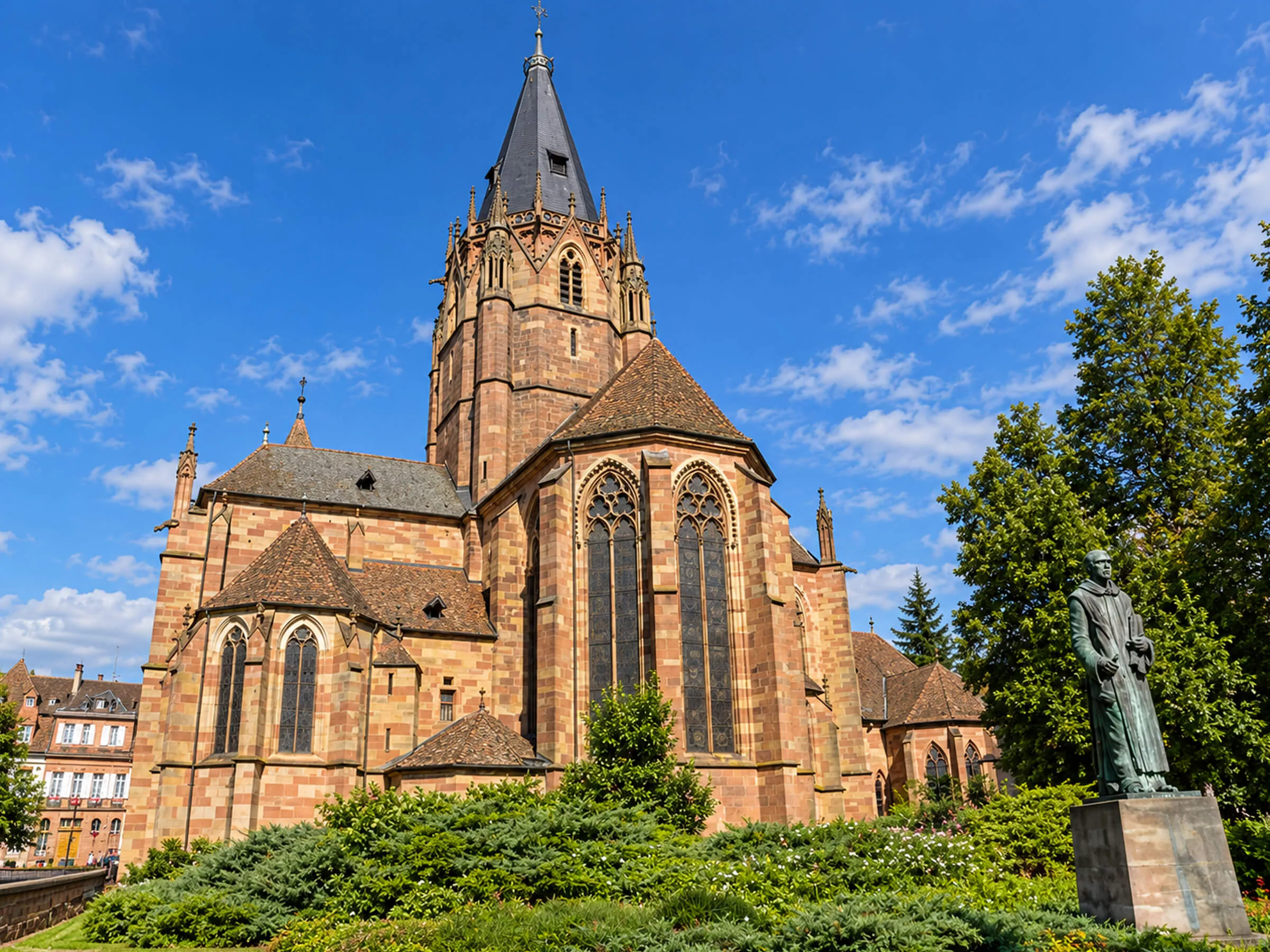 Église gothique en grès rose d’Alsace sous un ciel d’été